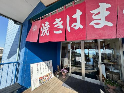 a store with a red sign on the side of a building at グランピング宿 星空テラス&暖炉の庭付き戸建 Orion in Miyamae