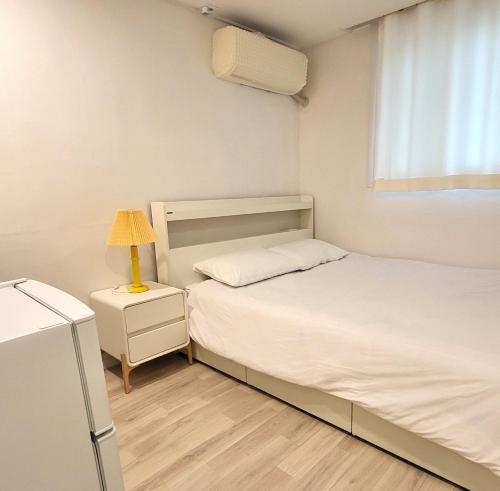 a bedroom with two beds and a lamp on a night stand at Humming stay in Seoul