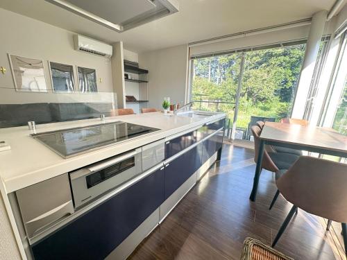a kitchen with a sink and a table and a window at グランピング宿 星空テラス&暖炉の庭付き戸建 Orion in Miyamae