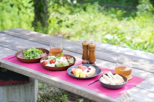 a picnic table with two plates of food and two glasses of beer at グランピング宿 星空テラス&暖炉の庭付き戸建 Orion in Miyamae
