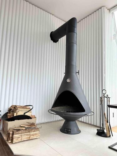 a black oven in a room with a wall at グランピング宿 星空テラス&暖炉の庭付き戸建 Orion in Miyamae