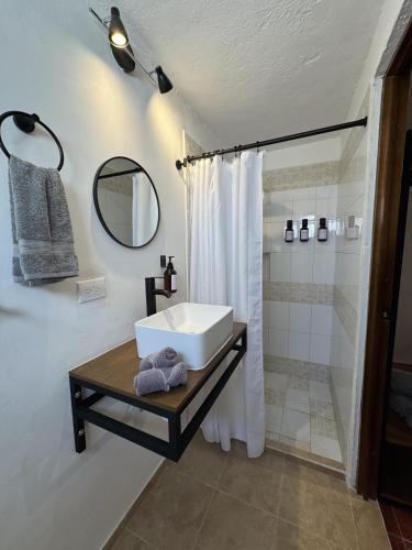 a bathroom with a white sink and a shower at The Boat House Suites in Cancún
