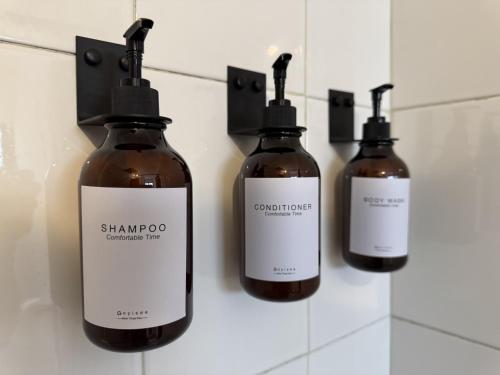 a group of three bottles of soap on a wall at The Boat House Suites in Cancún