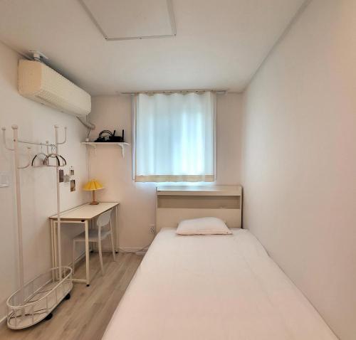 a small room with a bed and a window at Humming stay in Seoul