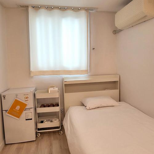 a small bedroom with a bed and a window at Humming stay in Seoul
