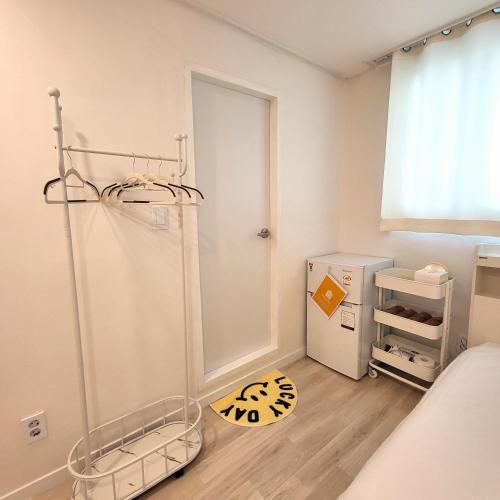a small bedroom with a refrigerator and a floor at Humming stay in Seoul