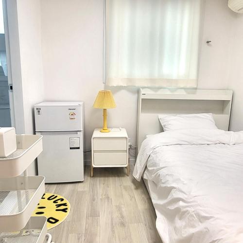 a small bedroom with a white bed and a window at Humming stay in Seoul