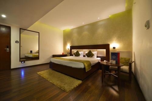 a bedroom with a large bed and a mirror at Tabla Pride Hotels & Spa in Hyderabad