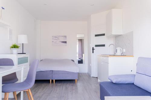 a small white room with a bed and a desk at Leśny Karwia - Pokoje 70m od Plaży in Karwia