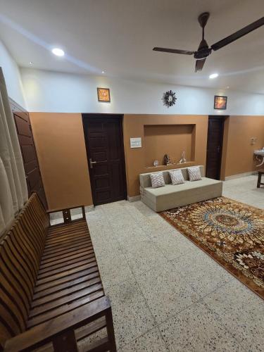 a living room with a couch and a ceiling fan at Kowdi Farm House in Eramalloor