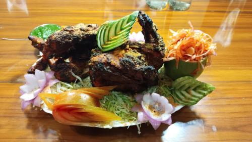 une assiette de nourriture sur une table en bois dans l'établissement Resort Morning Glory, à Lataguri