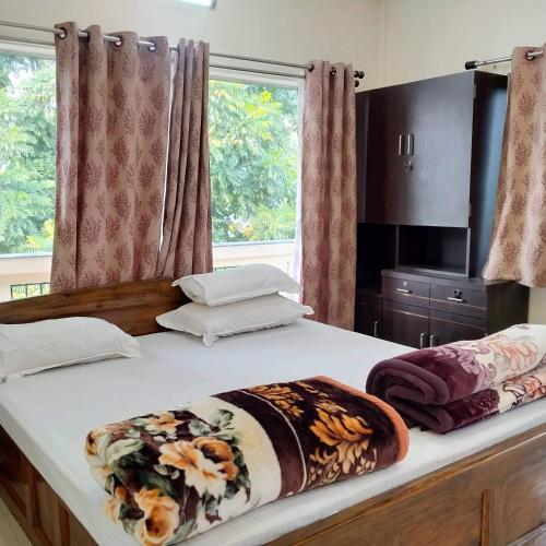 two beds in a room with two windows at Resort Morning Glory in Lataguri