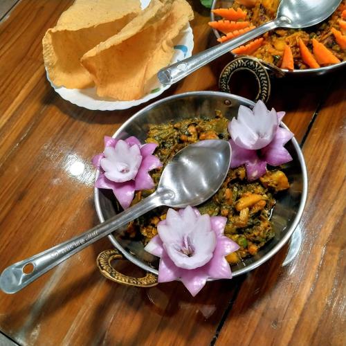 un bol de nourriture avec des fleurs sur une table dans l'établissement Resort Morning Glory, à Lataguri