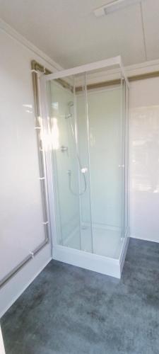 a bathroom with a glass shower in a room at Miła Łąka Glamping in Miłki