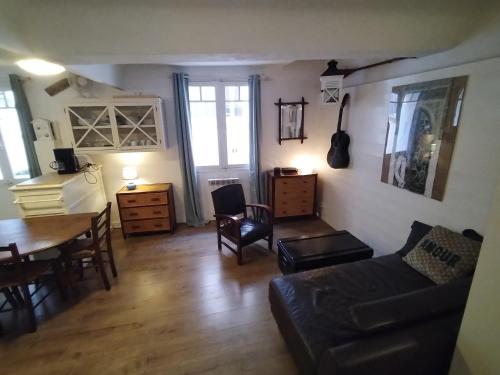 un salon avec un canapé, une table et des chaises dans l'établissement Bel appartement Port Sanary, à Sanary-sur-Mer