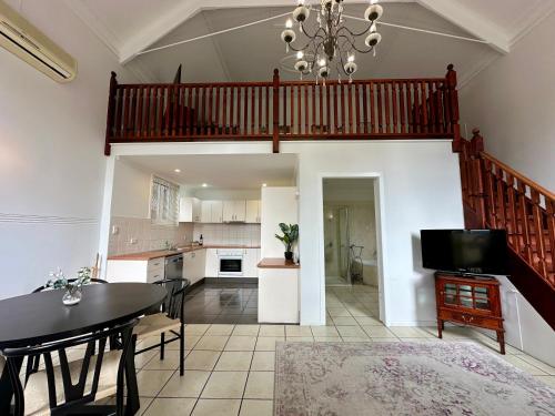 a living room with a dining room table and a staircase at Charlesworth On The Park in Glen Innes