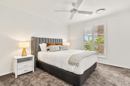 Un dormitorio con una cama grande y una ventana. en The Corlette Beach Retreat, en Corlette