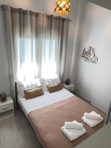 a bedroom with a bed with two towels on it at Barounia Suite in Iraklitsa