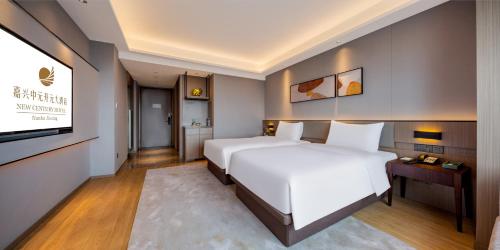 a bedroom with a large white bed and a flat screen tv at New Century Mansion Hotel Jiaxing Zhongyuan Nanhu Avenue in Jiaxing