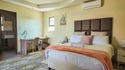 a bedroom with a large bed and a desk at Ondjo Yetu in Benoni