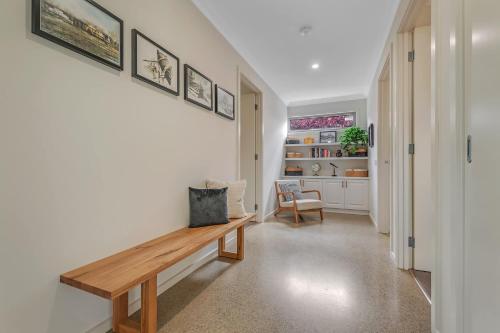 a hallway with a wooden bench on a wall at Moama on Clarke - Echuca Holiday Homes in Moama