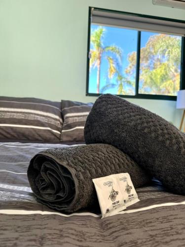 a blanket and pillows on a bed with a window at Coolgardie Caravan Park in Coolgardie