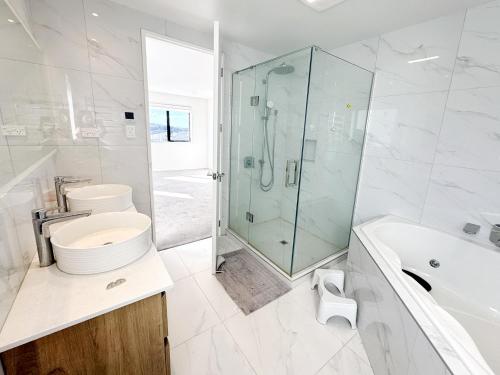 a bathroom with a shower and a toilet and a sink at Spacious 7 BRs 4 BHs house on Longhorn, Flat Bush in Auckland