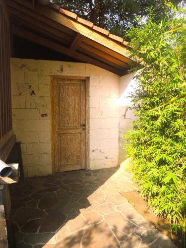 a brick building with a wooden door on it at Imalee - Cottage in Yogyakarta