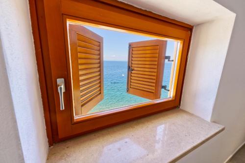 an open window with a view of the ocean at Apartments Punta Piran in Piran