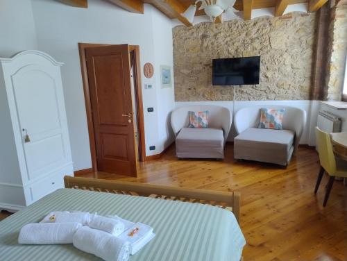 a bedroom with a bed and a living room at B&B QUINTARELLI in San Pietro in Cariano