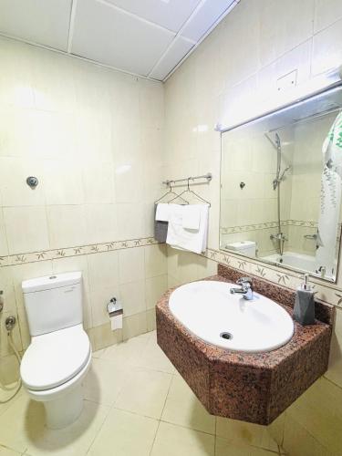 a bathroom with a toilet and a sink at La Pearl Vacation Home in Ajman 