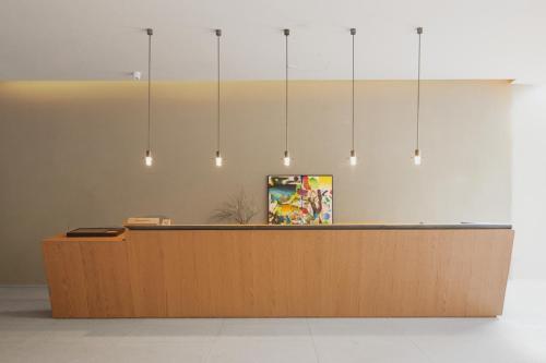 a lobby with a reception desk with lights at The Yard Boutique Hotel Shanghai 一隅酒店上海虹桥漕河泾店 in Shanghai