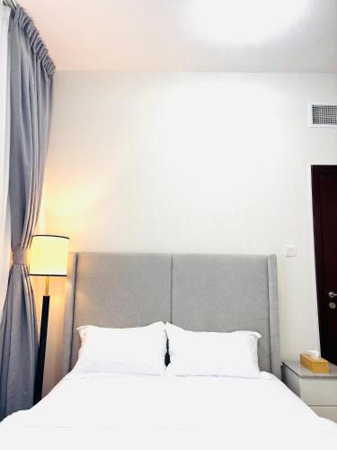 a bedroom with a large bed and a window at La Pearl Vacation Home in Ajman 