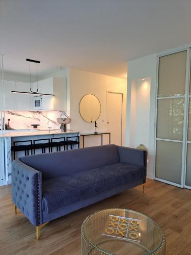 un salon avec un canapé bleu et une table dans l'établissement La Croisette Côté Lac, à Créteil