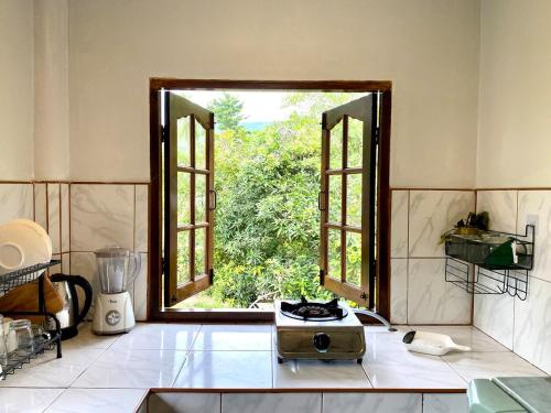 スリタヌにあるJungle Rock House in srithanuの開いた窓とブレンダーのあるキッチン