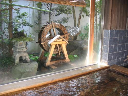 a garden with a windmill and a pond in a room at Yudanaka Yasuragi in Yamanouchi