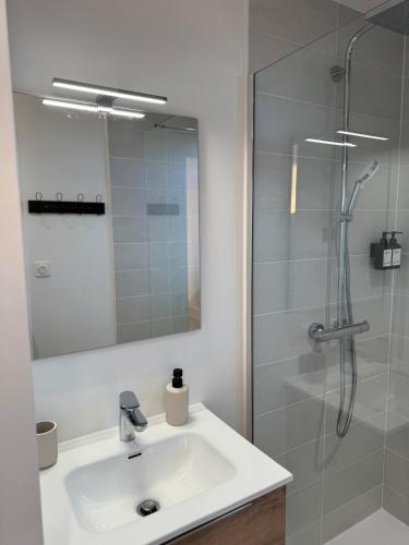 a white bathroom with a sink and a shower at Chalet 15 in Saint-Genès-Champespe