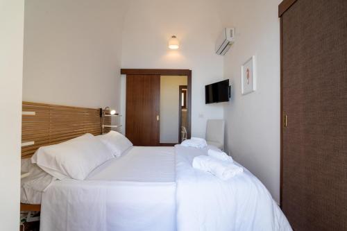 a bedroom with two beds with white sheets at Casa Scala in Acireale