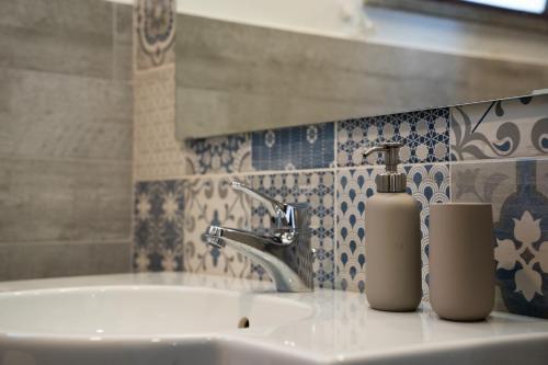 a bathroom sink with a soap dispenser on it at Casa Scala in Acireale