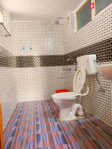 a bathroom with a toilet and a colorful floor at Golden Palace Royal in Leh
