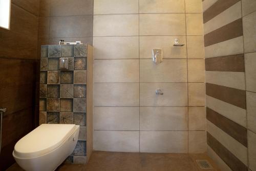 a bathroom with a toilet and a shower at Floresta Resort in Kūmudi