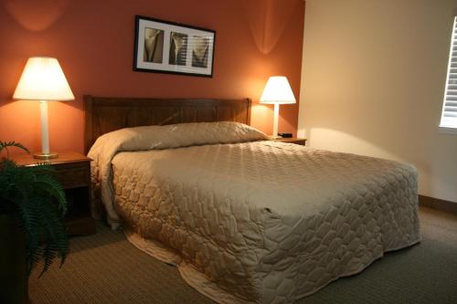 - une chambre avec un grand lit et deux lampes dans l'établissement Affordable Suites of America Fredericksburg, à Fredericksburg
