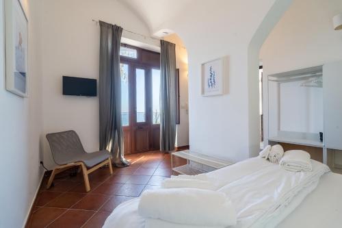 a hotel room with two beds and a chair at Casa Scala in Acireale