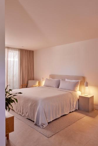 Un dormitorio blanco con una cama grande y una ventana. en The Hide Byron Bay, en Byron Bay