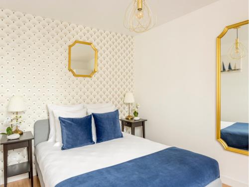 - une chambre avec un lit bleu et blanc et un miroir dans l'établissement Merveil - Family Suite - Marais - Martin VI, à Paris
