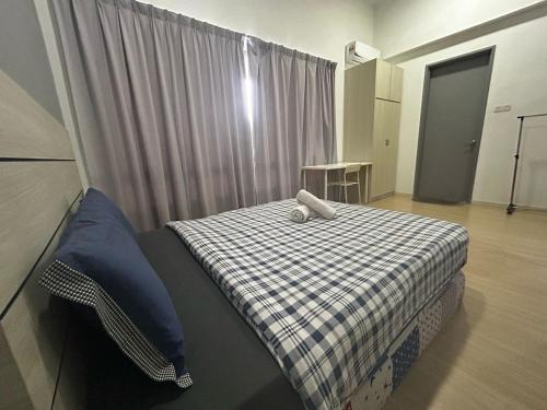 a small bedroom with a bed with a checkered blanket at USJ One home stay in Subang Jaya