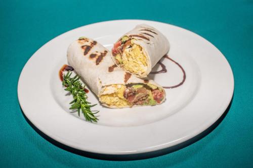 a white plate with a burrito on a table at 7 Eland Boutique Guest House in Ladismith