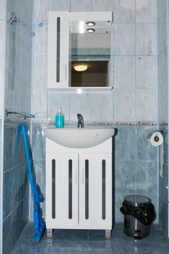 a bathroom with a white sink and a mirror at Samuil Apartments - Central Burgas in Burgas