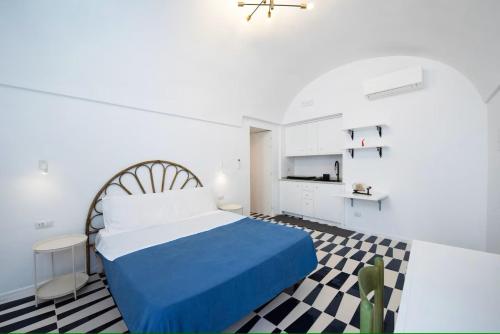 a bedroom with a blue bed and a checkered floor at Le tre sirene depandance in Atrani