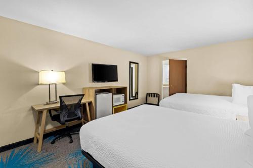a hotel room with two beds and a desk with a computer at Days Inn by Wyndham Tucson Airport in Tucson